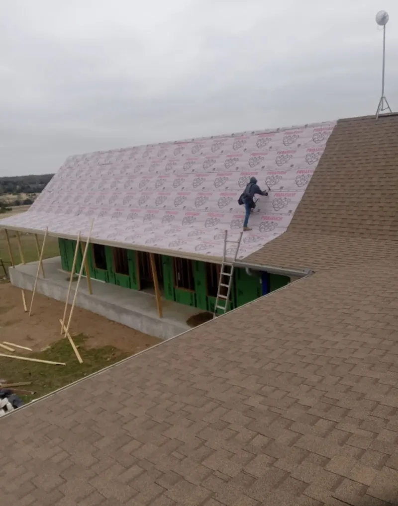 Worker preparing underlayment for a metal roof installation in Vashon